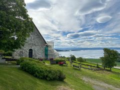 steinkirke fra middelalderen sakshaug gamle kirke Trøndelag i vårsol med blå fjord i bakgrunnen