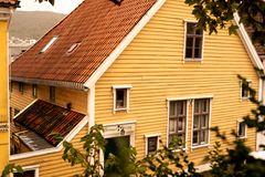 Bygning, gul, stranges stiftelse i bergen med litt løv i forgunnen
