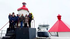 Gruppebilde foran den nye fyrlykten ved Horten, med den gamle fyrlykten til høyre og Kystverkets OV Ryvingen i bakgrunnen.