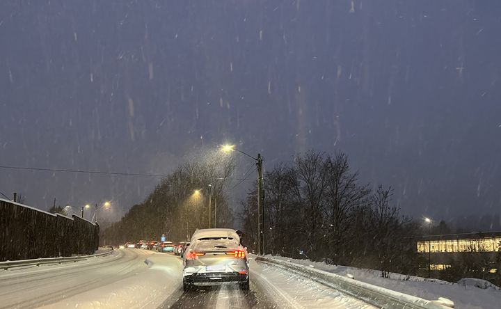 Bilde av bil med snø på taket og bilkø