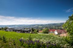 Bilde av landskap med hus og en småby i horisonten.