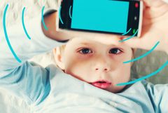 Barn og mobiltelefon: Illustrasjon som viser trådløs stråling. En ny rapport fra Folkehelseinstituttet har utløst faglig og offentlig debatt. (Illustrasjonsfoto: Shutterstock)
