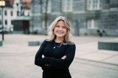 Kvinne med armene i kors, ser i kameraet