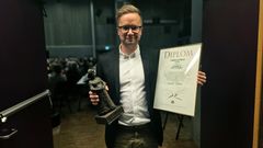 Mann med diplom og statuett