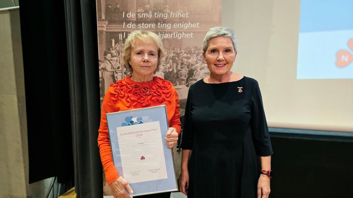 To kvinner, den ene holder et diplom.