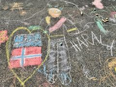 TEGNET TIL KONG HARALD: Barna satte sitt preg på Akershusstranda under Oslo havnelangs 2026 med et fargerikt kunstverk laget med kritt. Mange valgte å tegne motiver til Kong Harald.