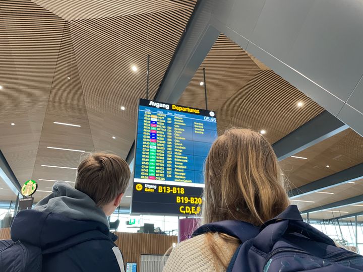 Passasjerer følger med på informasjonstavle på flyplassen.