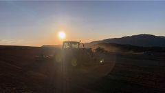 John Deere i solnedgang under etablering av ny slåttemark på Vestlandet.
