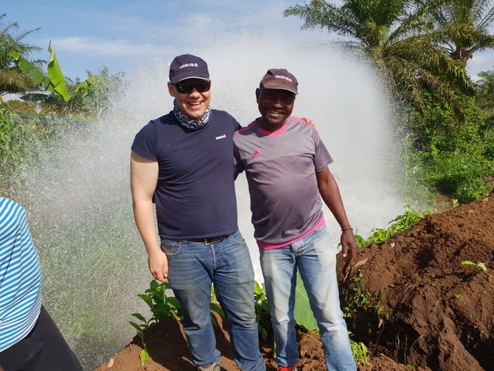 Viggo Bjerkelund, engineering manager i Inrigo i Norge, sammen med Mr.Polycap fra det lokale Inrigo teamet i Kamerun med en «fontene» av rent vann strømmende ut fra et testuttak i det nye vannbehandlingsanlegget i Nkam.