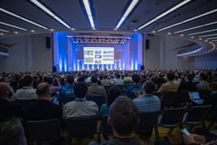 En stor konferansesal full av mennesker som følger med på en presentasjon.