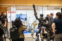 A robot on display at the European Robotics Forum 2024, surrounded by people and cameras.