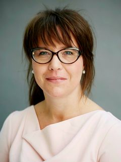 Portrettbilde av kvinne med mørkt hår og briller