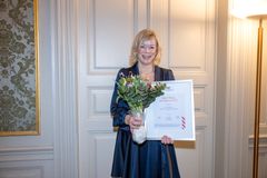Bilde av flysykepleier Tone Raasok som mottar diplom og blomster når hun tildeles Marit Ribes minnespris.