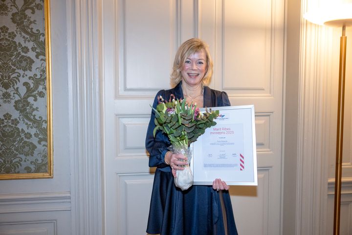 Bilde av flysykepleier Tone Raasok som mottar diplom og blomster når hun tildeles Marit Ribes minnespris.