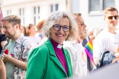 Biskop Kari Veiteberg i grønn jakke og lila bispeskjorte i Oslo prideparade.