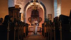 Hvordan vet jeg når jeg skal stå eller sitte, er noe mange lurer på. Det enkle svaret er at presten viser tydelig tegn når det er tid for å stå eller sitte. (Foto: Willy / Den norske kirke).
