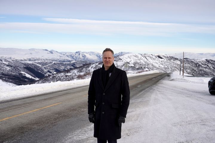 Samferdselsminister Jon-Ivar Nygård står foran en snødekt rv.13 ved Vikafjellstunnelen