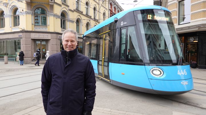 Samferdselsminister Nygård foran en trikk i Oslo sentrum.
