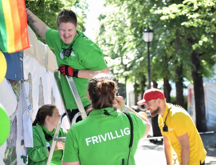 En gurppe frivillige rigger ned et arrangement, mens de snakker og smiler