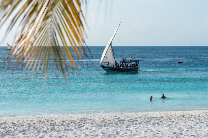 En strand på paradisøy med en båt i gammel, afrikansk stil.