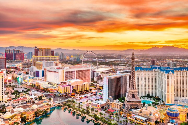 Oversiktsbilde over Las Vegas med skyskrapere, neonlysskilt og Eiffeltårnet-replikaen langs the Strip.