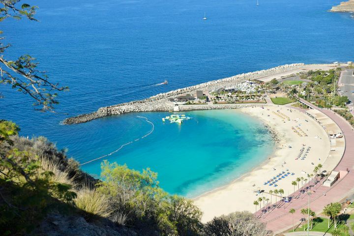 En strand foran blått hav på øya Gran Canaria.