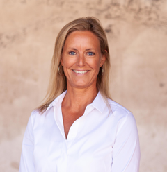 Portrettbilde av en solbrun Lisa Rönnberg som er nordisk markedsdirektør i TUI. Hun har på seg en hvit skjorte.