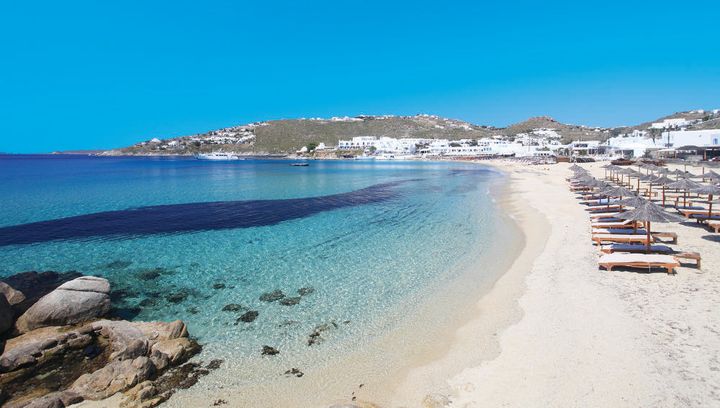 Den kritthvite stranden Plati Yialos på Mykonos i Hellas.