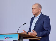 Sebastian Ebel, CEO of TUI Group standing behind a podium with the TUI-logo