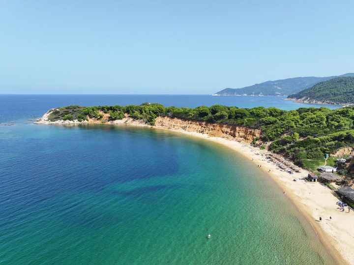 Mandraki beach på Skiathos med trær i bakgrunnen.