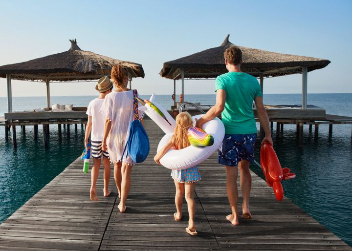 A family on holiday walking towards the ocean