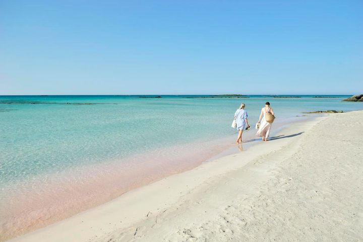 Et par som rusler langs Elafonissi-stranden på Kreta.