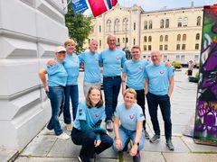 Ansatte på TUI-kontoret i Norge ved Karl Johan med norsk flagg.