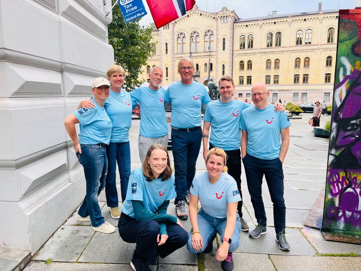 Ansatte på TUI-kontoret i Norge ved Karl Johan med norsk flagg.