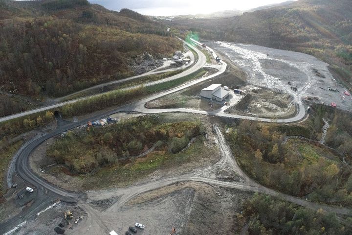 Foto av industriområdet hvor den nye stasjonen skal bygges inntil dagens eksisterende stasjon, som står midt i bildet.