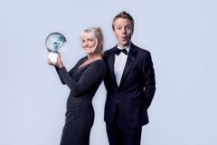 En mann og en kvinne, han i smoking og hun i sort glitrende kjole. Kvinnen løfter et Idrettsgalla-trofé.