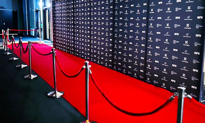 En%20tom%20r%F8d%20l%F8per%20og%20pressevegg%20med%20logoer