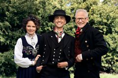 Nadia Hasnaoui, Kashayar Afshar, Olav Viksmo-Slettan smiler i bunad foran grønskende natur