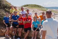 Deltakerne i Mesternes mester team på stranden i Hellas. Foran fra venstre: Liv Grete Skjelbreid, Emil Hegle Svendsen, Solveig Gulbrandsen, Marco Elsafadi, Helene Spilling og Stig-André Berge. Bak: Frode Grodås, Astrid Lødemel, Steffen Iversen, Kjersti Grini, Johanne Killi og Emil Lybekk. Programleder Aksel Lund Svindal med ryggen til.