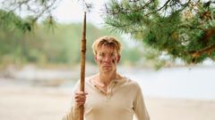 Beskriv bildet (alternativ tekst, synlig for publikum) En mann med spyd på en strand som ser inn i kameraet