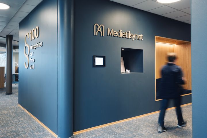 Inne i Medietilsynets kontorlokaler. Det står Medietilsynet på veggen.