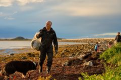 Man rydder strandet med hunden sin.