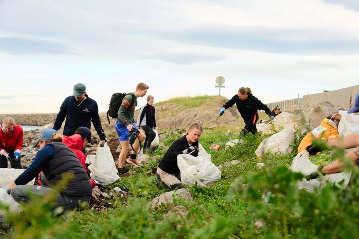 flere strandryddere med søppelsekker som rydder