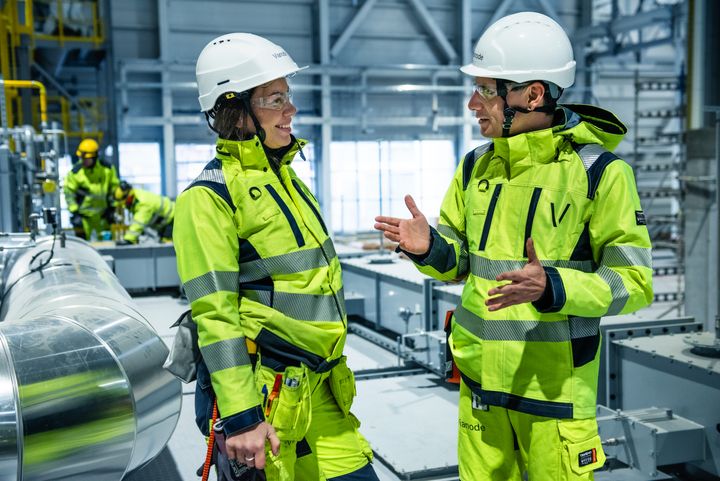 To arbeidere i batterifabrikk med signalgrønne beskyttelsesklær