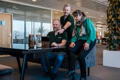 Administrerende direktør Arve Jakobsen (f.v.), teknisk sjef Bjørnar Tunheim og HMS-sjef Vibeke Aarseth i Recuro AS ser på en datamaskin i et kontorlandskap.