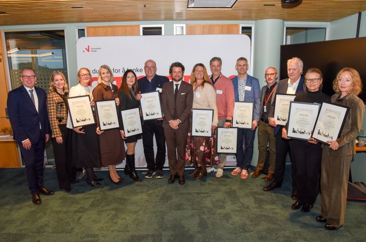 Gruppebilde av representanter fra klyngene som er tatt opp i Norwegian Innovation Clusters, samlet på rad og holder diplomer.