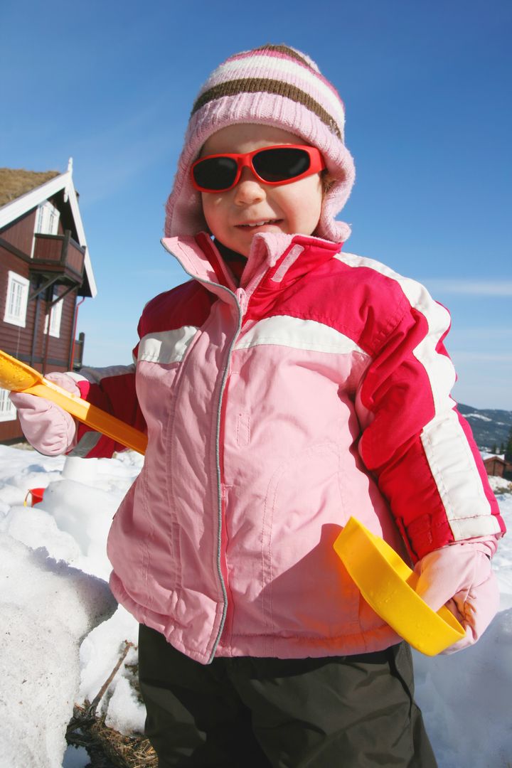 barn med solbriller i snøen