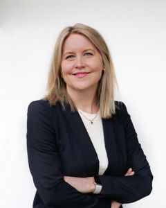 Dame i blå blazer med armene i kryss