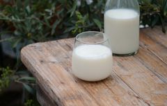 To melkeglass med natur i bakgrunnen