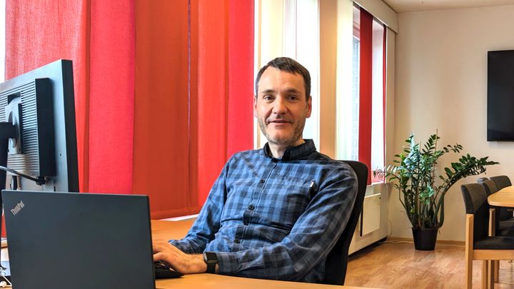 Bilde av Per Inge Bjerknes som sitter ved kontorpulten med pc, skjerm og tastatur.